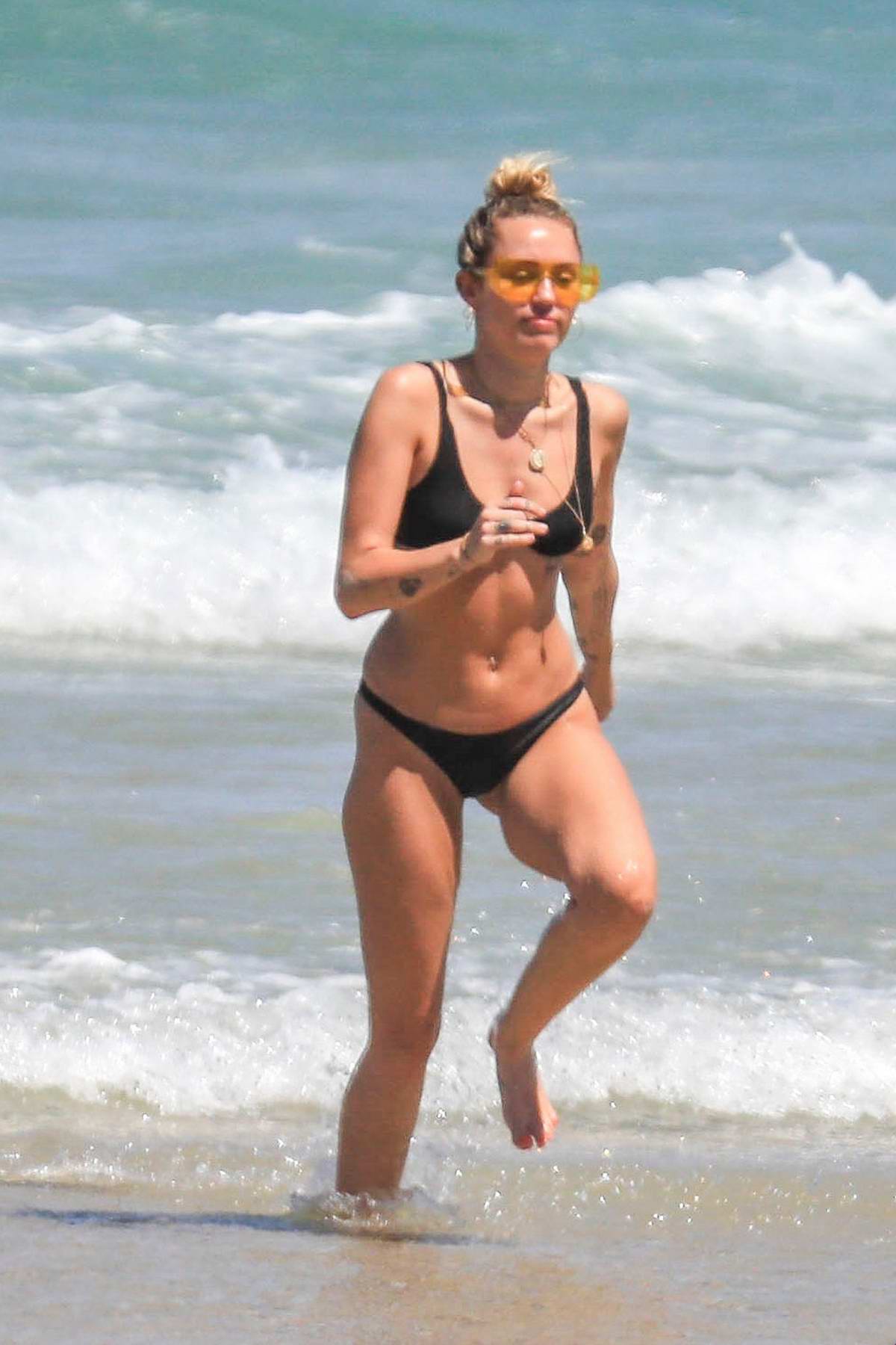 miley cyrus enjoying the beach in a black bikini in byron bay