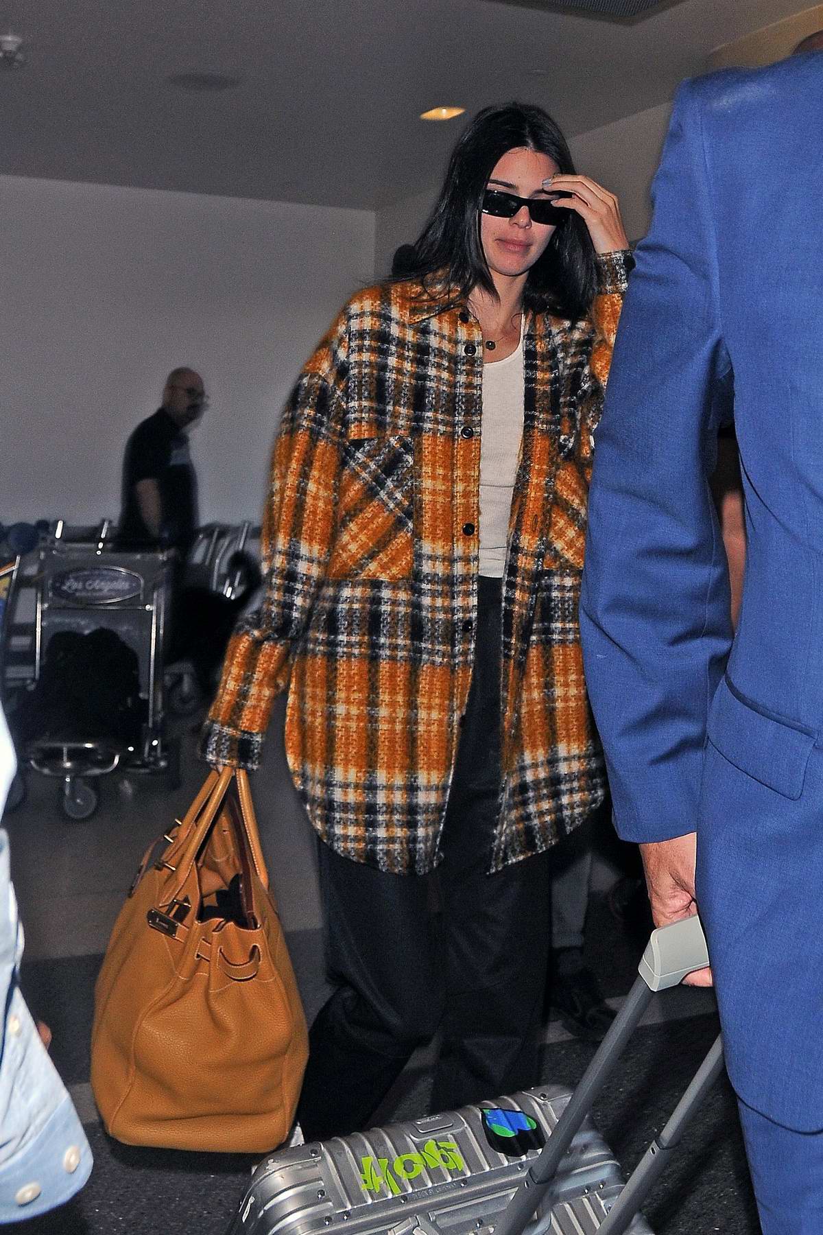 Kendall Jenner tries to avoid the camera as she arrives at LAX airport
