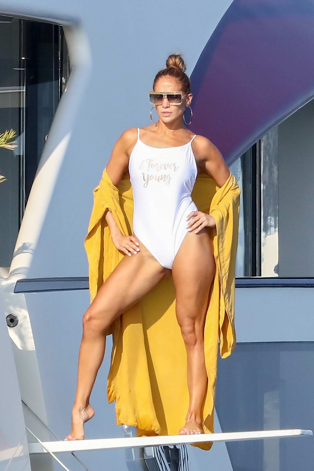 jennifer lopez poses in a white swimsuit during a photoshoot on her