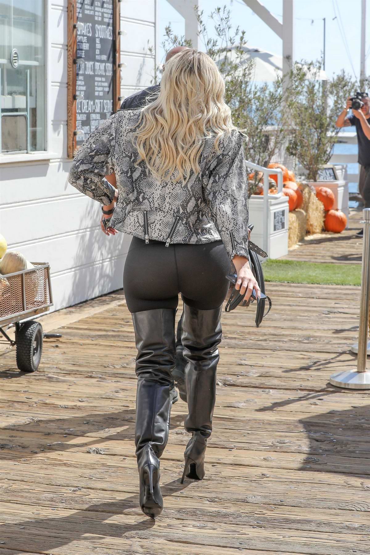 khloe kardashian wears snakeskin jacket with black leggings and thigh