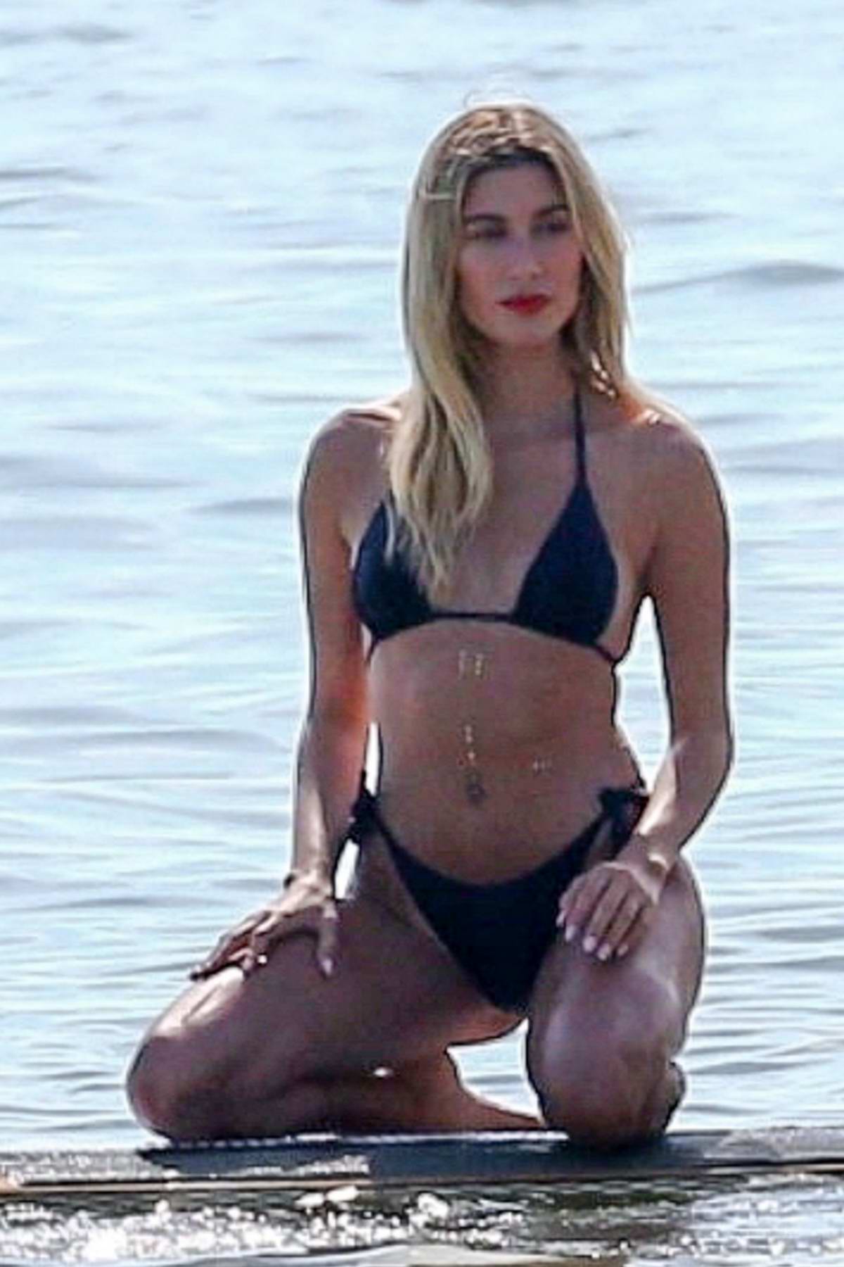 hailey bieber poses in a blue bikini during a beach photoshoot at key