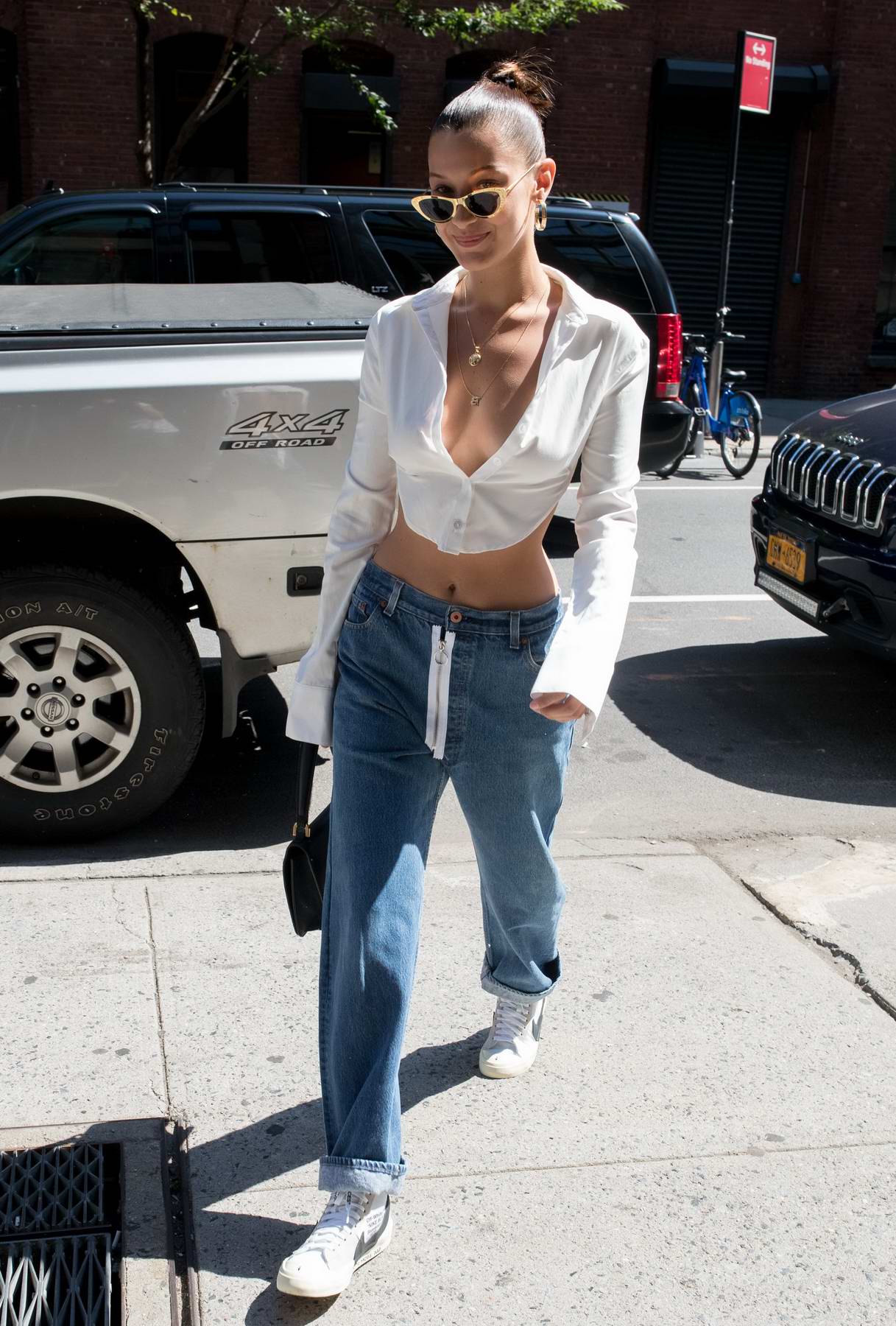 bella hadid in deep cut white top and jeans seen out and about in new ...