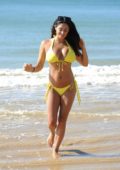Casey Batchelor in a yellow bikini on beach in Portugal