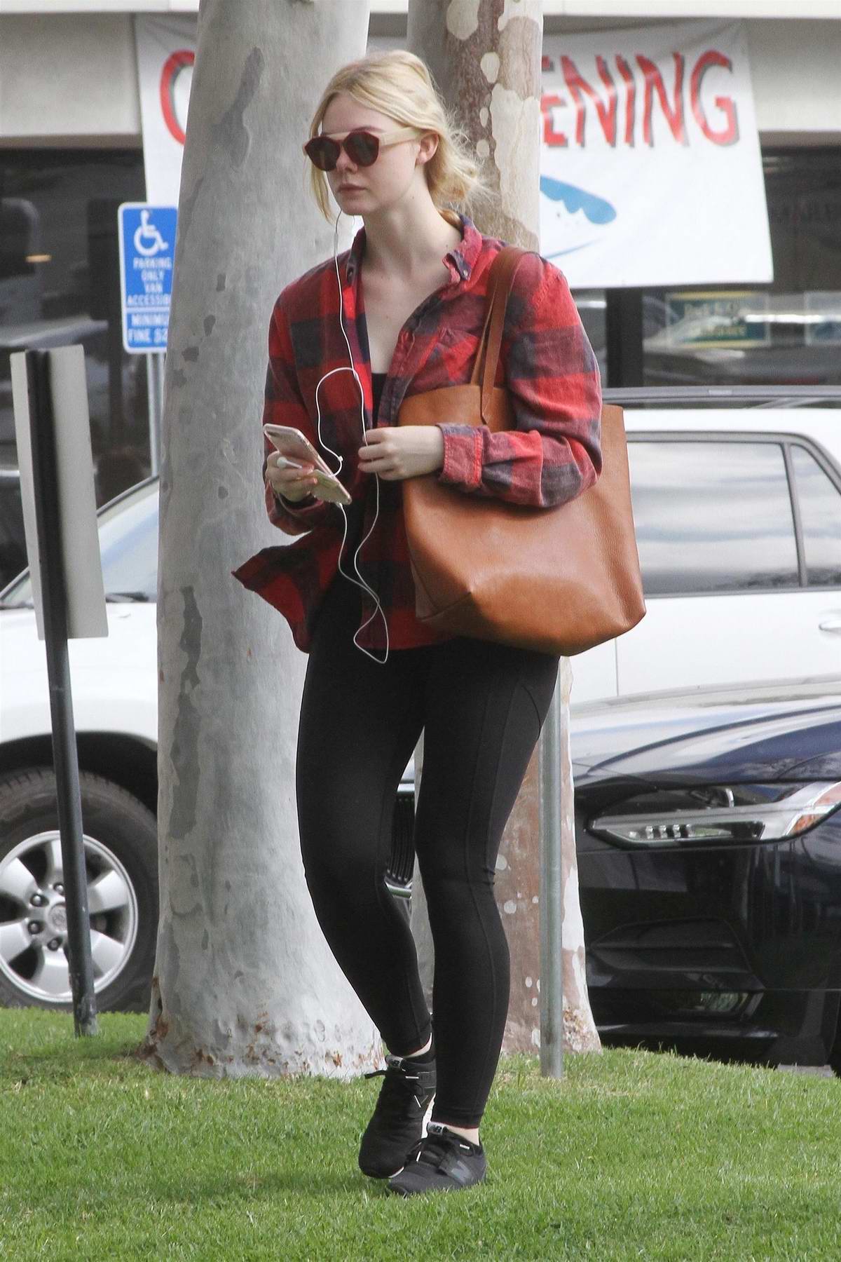 Elle Fanning wore red flannel shirt over a black sports bra with black  leggings as she