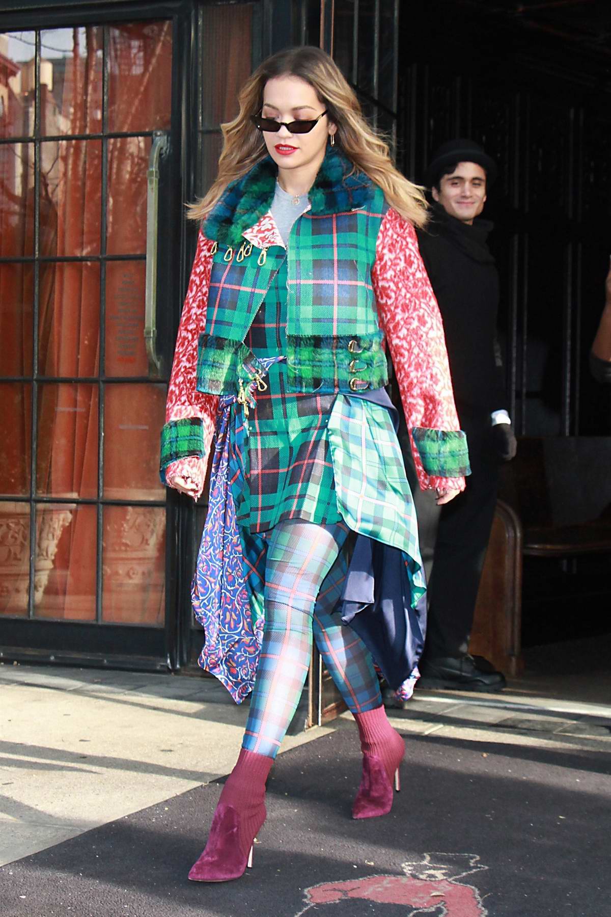 rita ora dressed in a colorful plaid outfit as she heads to the