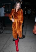 Emily Ratajkowski wearing an orange velvet robe coat and red boots while out for a stroll in New York City