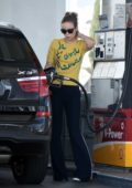 Olivia Wilde spotted in a yellow top and bell-bottom pants while pumping gas in Los Angeles