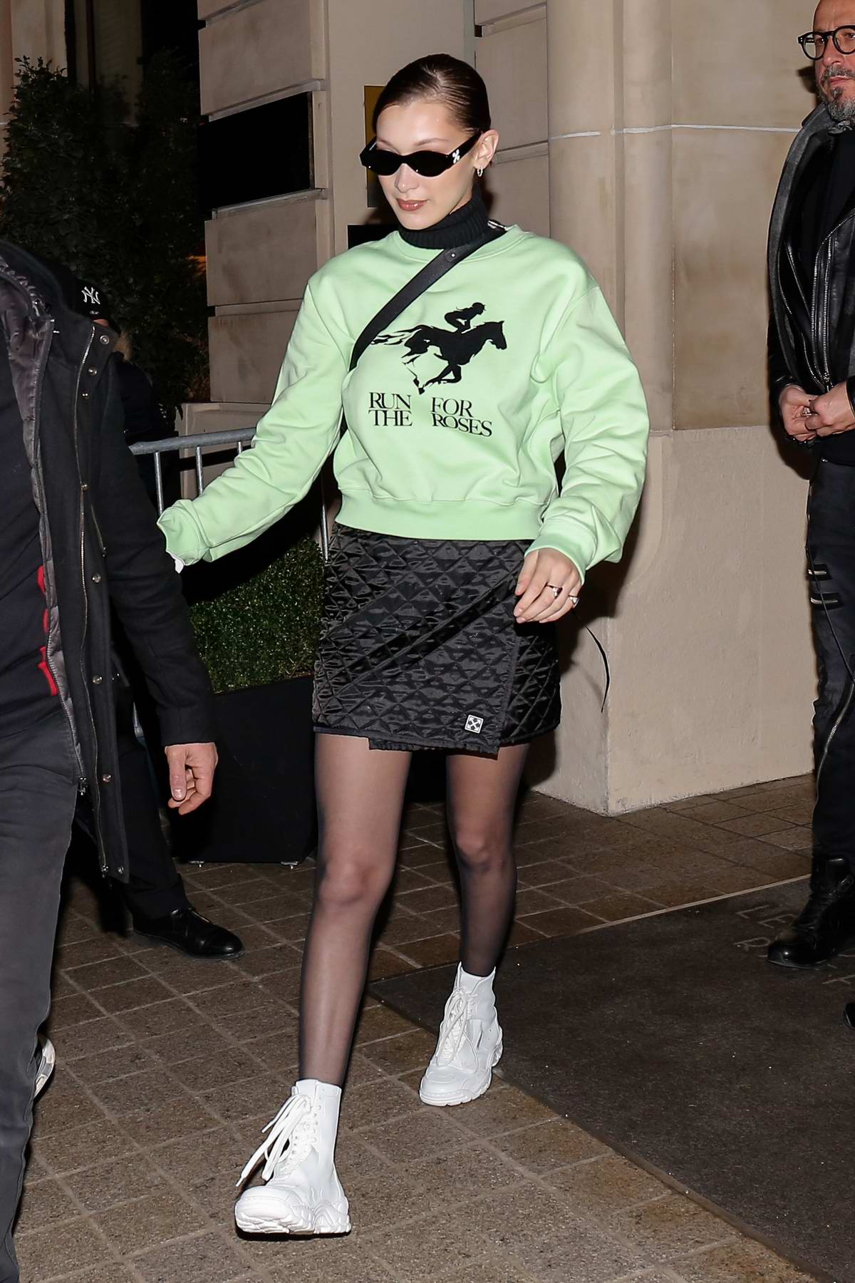 bella hadid steps out of her hotel wearing a green top, later she stops ...