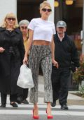 Charlotte McKinney looks chic in white crop top with patterned trousers and red high heels as she grabs some food to-go at La Scala in Los Angeles