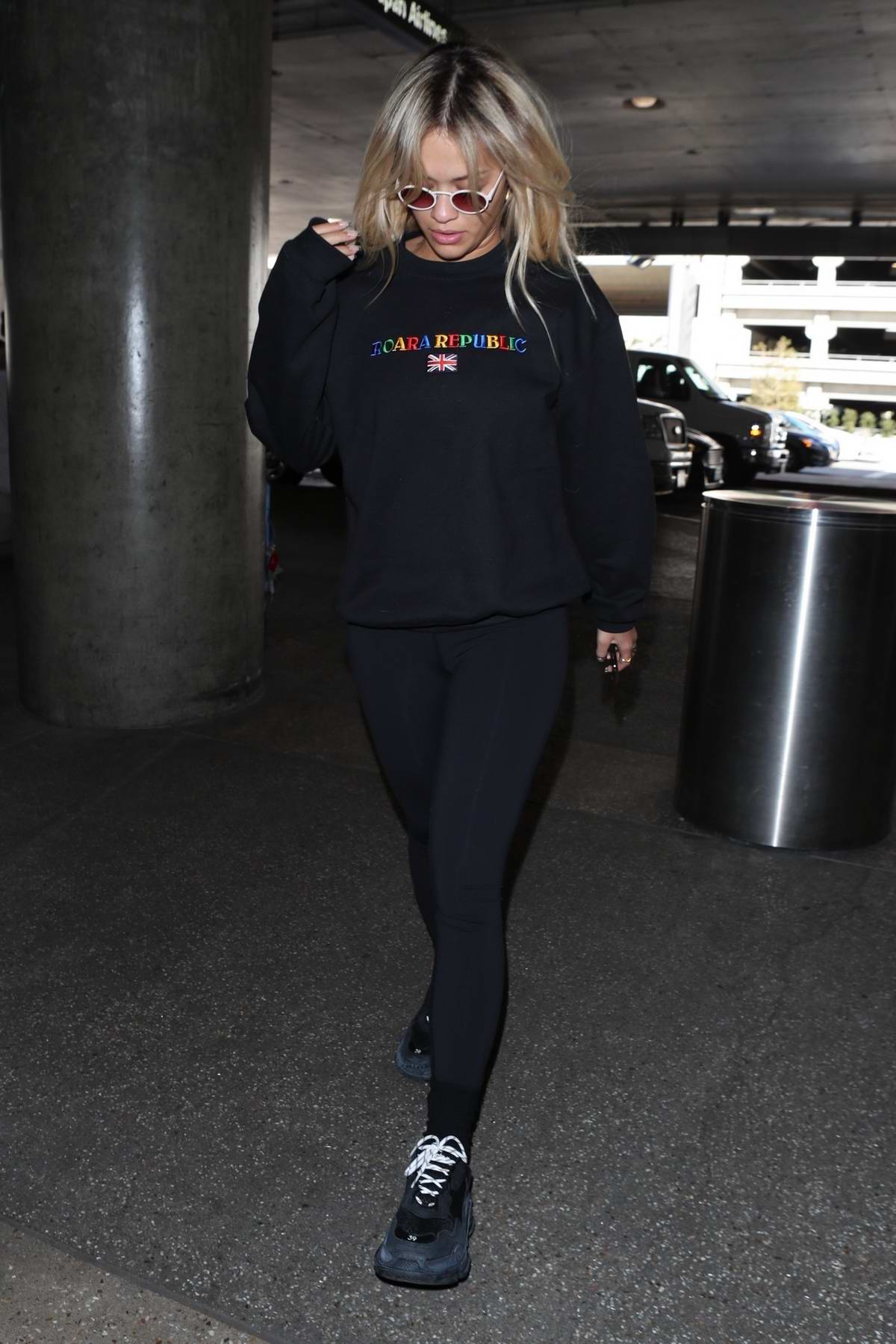 Rita Ora leaving her home in a black tracksuit, and transporting