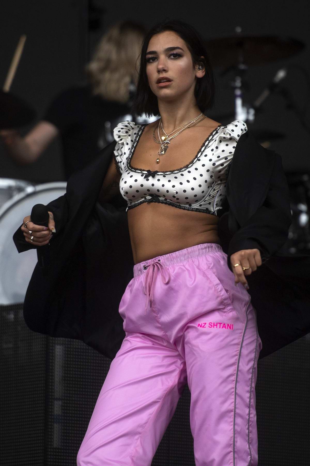 Dua Lipa performs at Leeds Festival 2018 in heavy rain while wearing pink  trousers and a