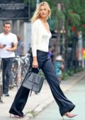 Karlie Lloss steps out wearing a white plunging neckline top with navy trousers in New York City