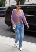 Bella Hadid wore a purple cardigan and jeans with white boots as she arrived at her apartment in New York City