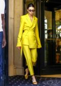 Kendall Jenner steps out of her hotel wearing a bright yellow suit during Paris Fashion Week in Paris, France