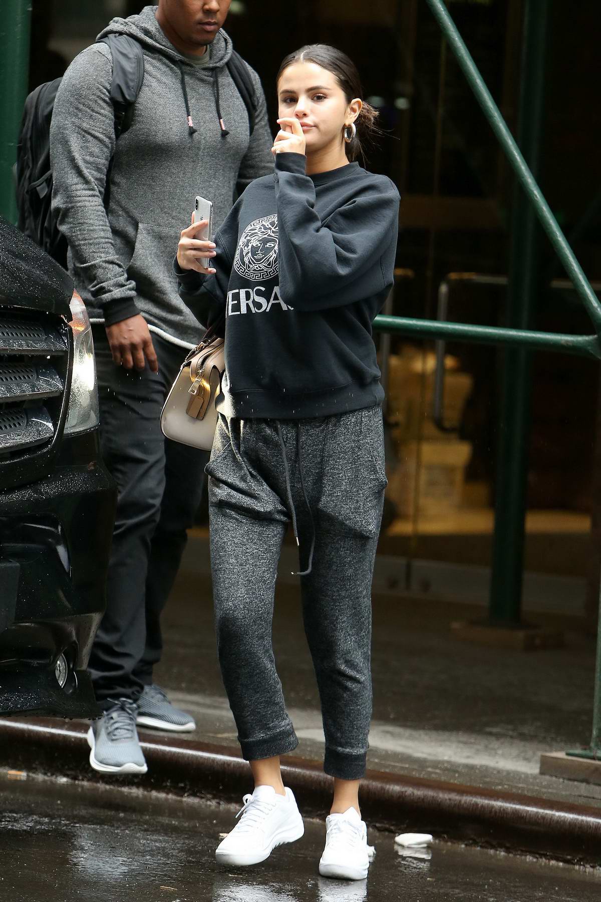 Selena Gomez wears a grey Versace sweatshirt with matching sweatpants as  she steps out to grab
