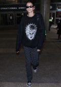 Kaia Gerber wears a 'Hellraiser' sweater with polka dot pants as she arrives at LAX airport in Los Angeles