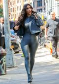 Kim Kardashian rocks dark grey leather bodysuit with matching boots and  cropped denim jacket while out