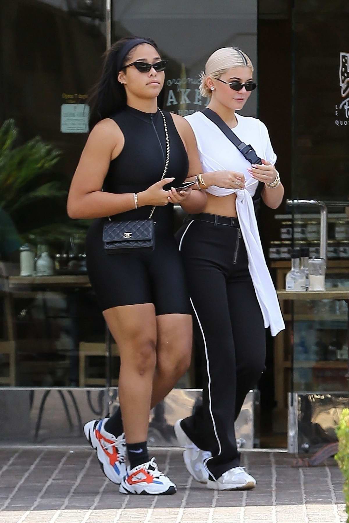 Kylie Jenner wore a white crop top, black pants and sneakers while out  shopping with BFF