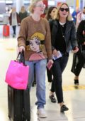 Olivia Wilde and Elle Fanning share a laugh as they arrive together at JFK airport in New York City
