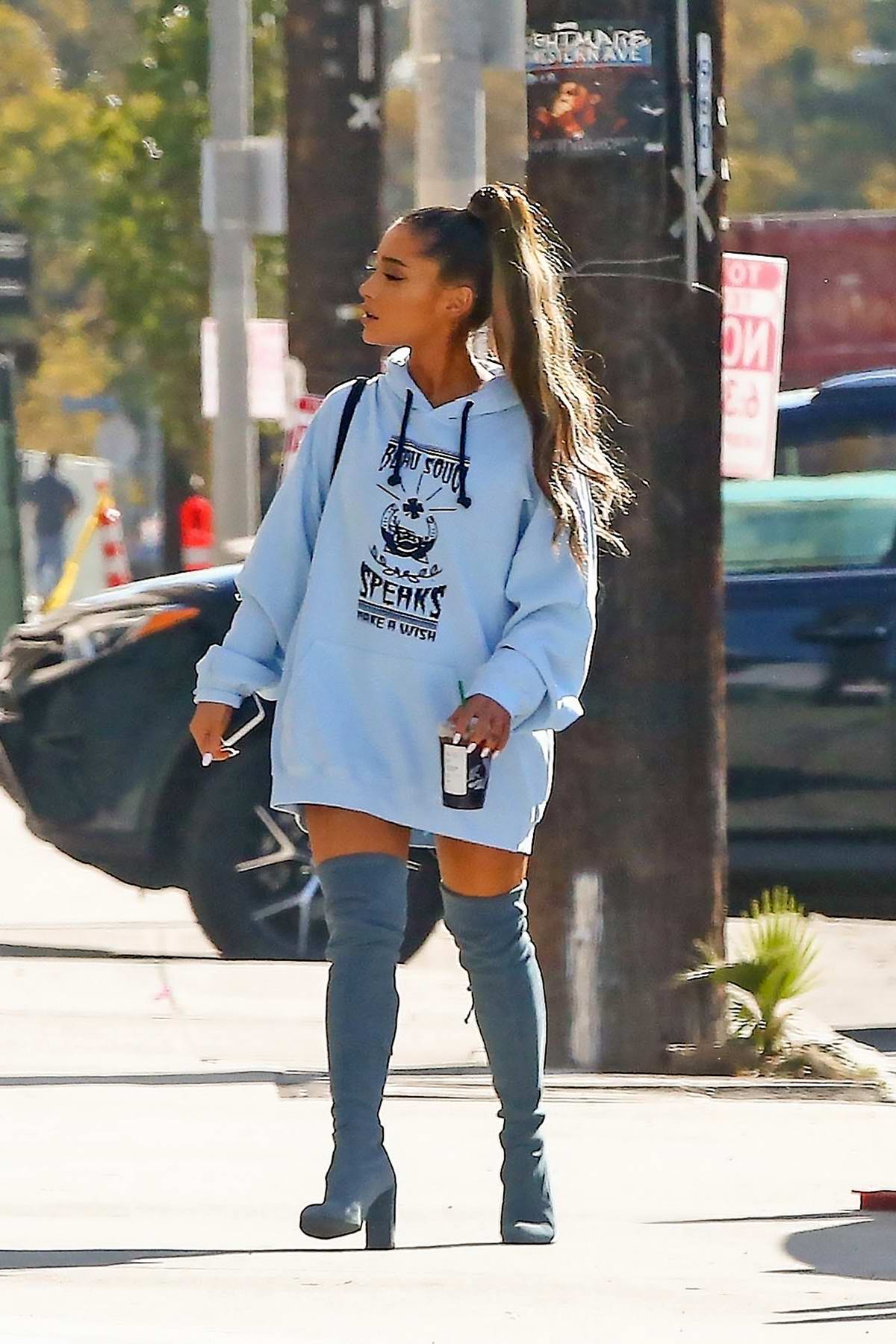 ariana grande wore a blue hoodie and knee high boots as she arrives at