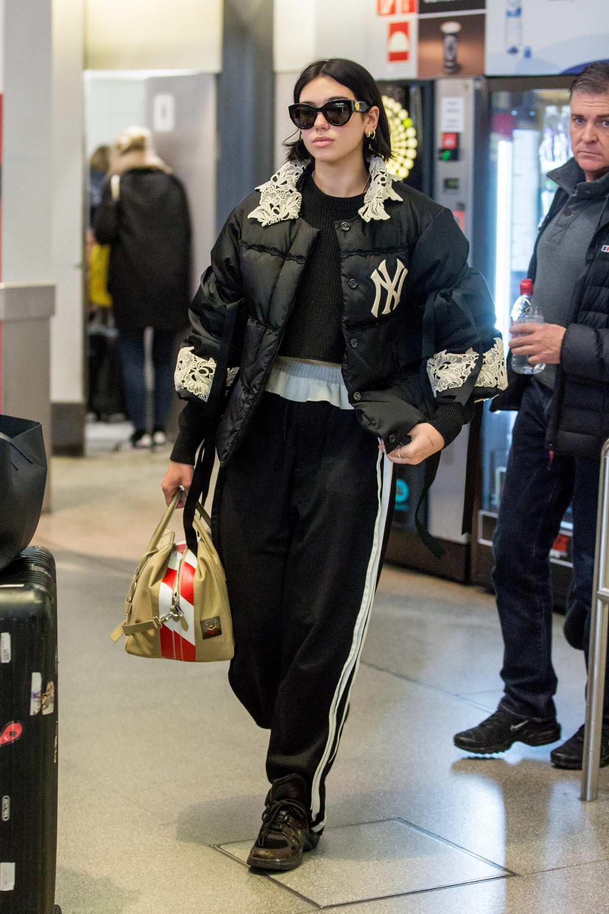 Dua Lipa rocks a lace-trimmed puffer jacket, track pants and Louis Vuitton  sneakers as she