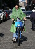 Kendall Jenner seen wearing a fur-trimmed green trench coat while out riding a Citi Bike with friends in SoHo, New York City