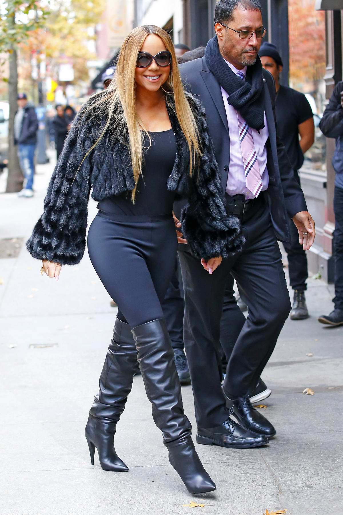 Mariah Carey wears black fur coat, black leggings with a pair of