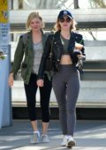 Lucy Hale wears leather jacket, green sports bra with grey leggings and trainers, while heading to the gym after grabbing an iced coffee in Los Angeles