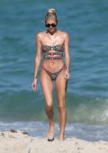 Devon Windsor shows off her beach body in a leopard print bandeau bikini as she spends the afternoon with her friend on Miami Beach, Florida