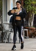 eva longoria sports a form-fitting black top with leggings while