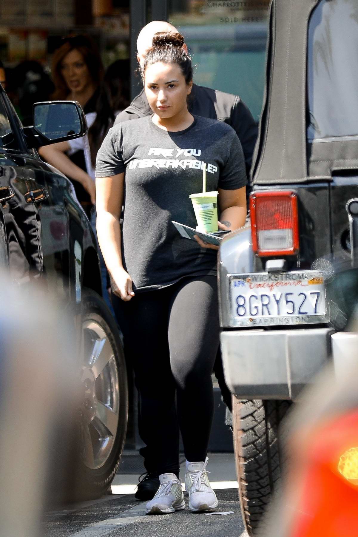Demi Lovato spotted in a dark grey tee and black leggings as she grabs some  juice