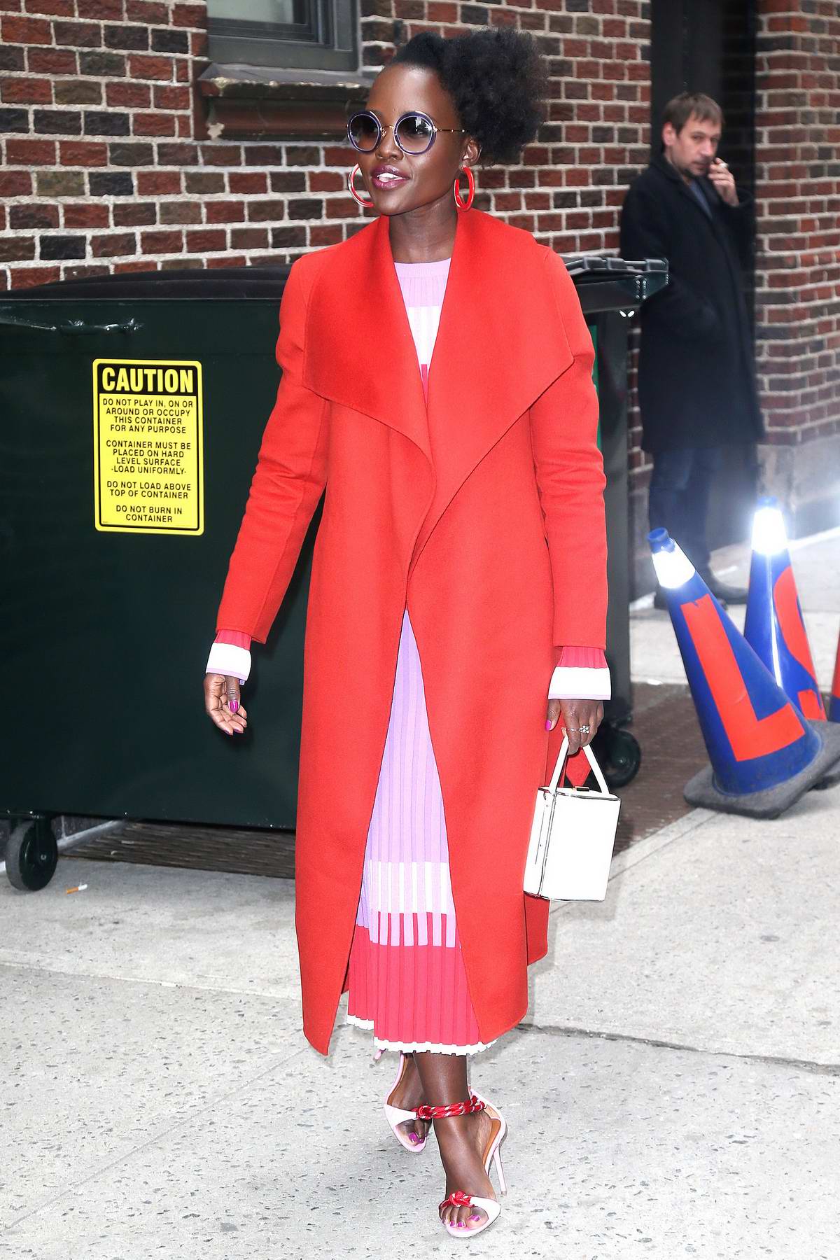 lupita nyong'o stands out in a bright red coat while visiting 'the late ...