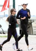 Karlie Kloss wears a blue and black sweatshirt with black leggings while out for a run in Venice, Italy