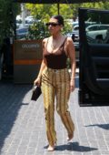 Kourtney Kardashian rocks a brown tank top and snakeskin print pants as she arrives at Cecconi's for lunch in Los Angeles