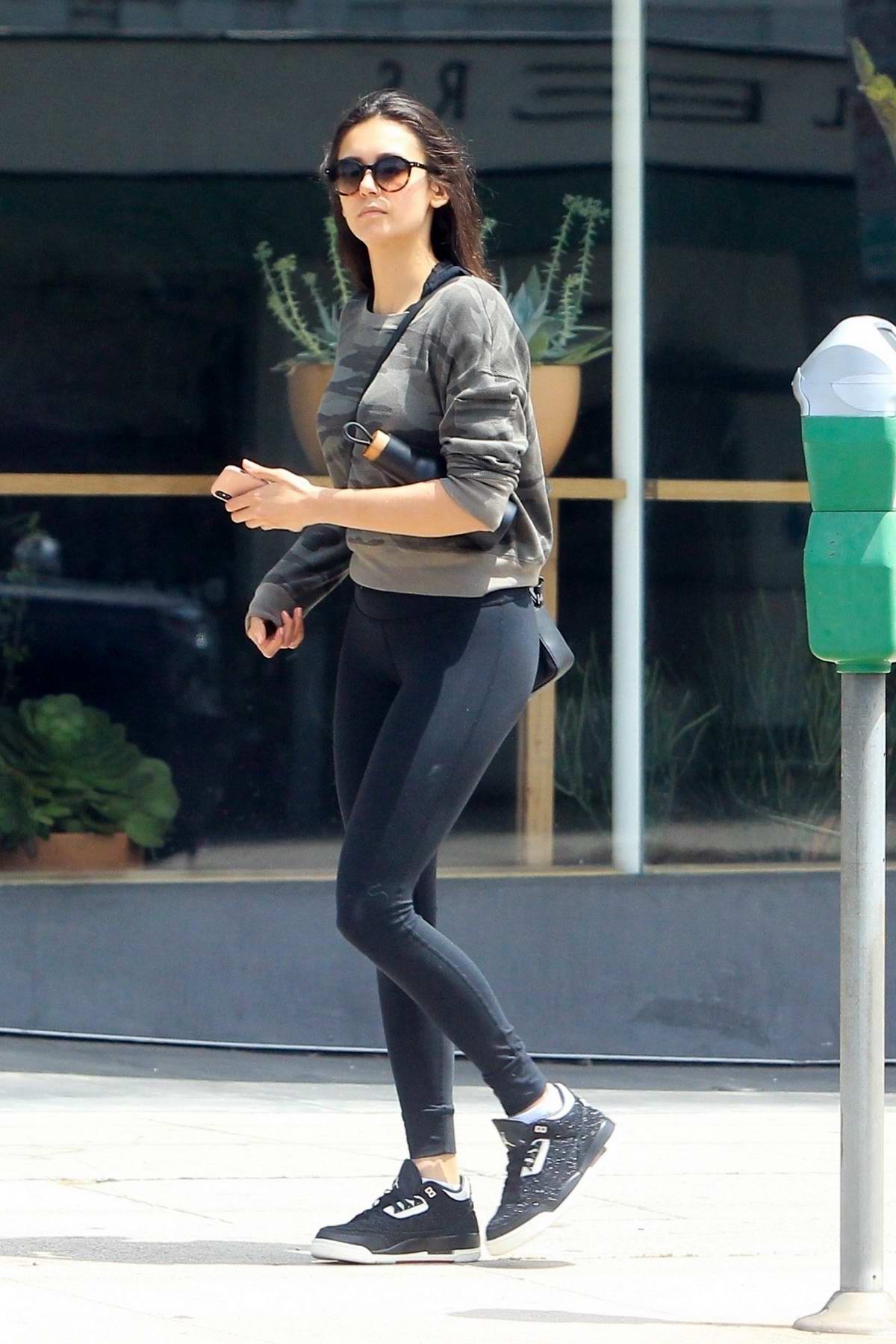 nina dobrev rocks grey camo sweatshirt and black leggings while