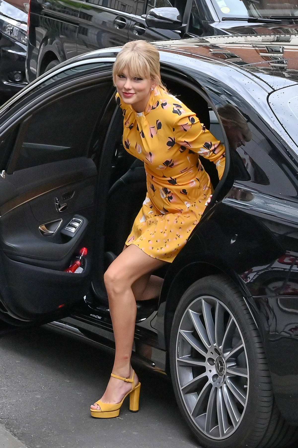 taylor swift wears a cute yellow dress as she greets her fans while  visiting nrj radio station in paris, france-250519_1