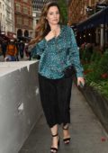 Kelly Brook seen wearing a blue silk animal print top and black pants as she steps out in London, UK