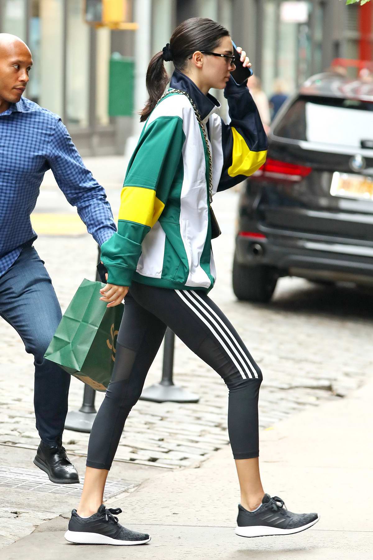 Kendall Jenner in lime yellow Adidas sneakers and black leggings