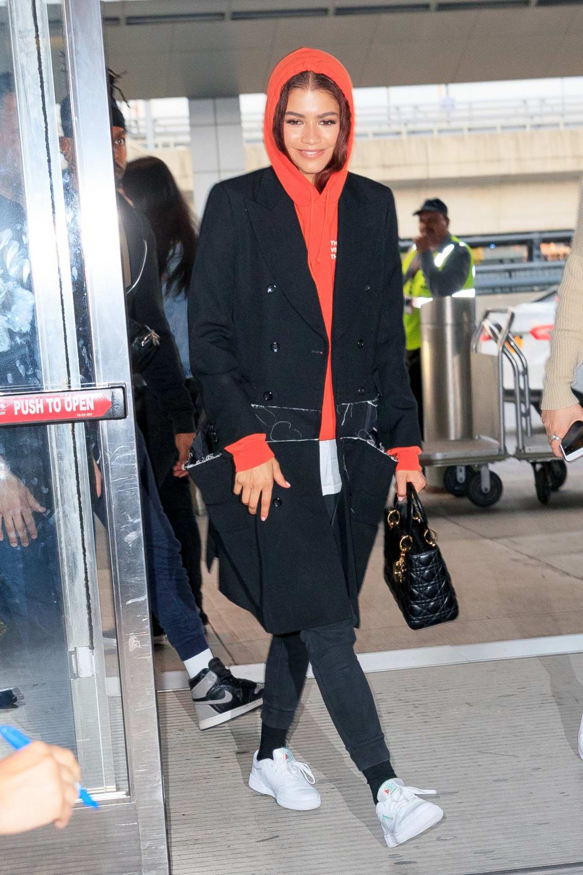 zendaya arrives in a red hoodie at jfk airport in new york city-250619_2