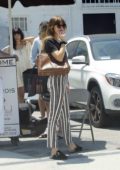 Dakota Johnson looks stylish in stripes while waiting for her ride after visiting a Beauty Spa in San Fernando Valley, California