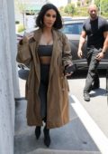 Kim Kardashian dons matching grey outfit with a trench coat while stopping by an art supply store in Los Angeles