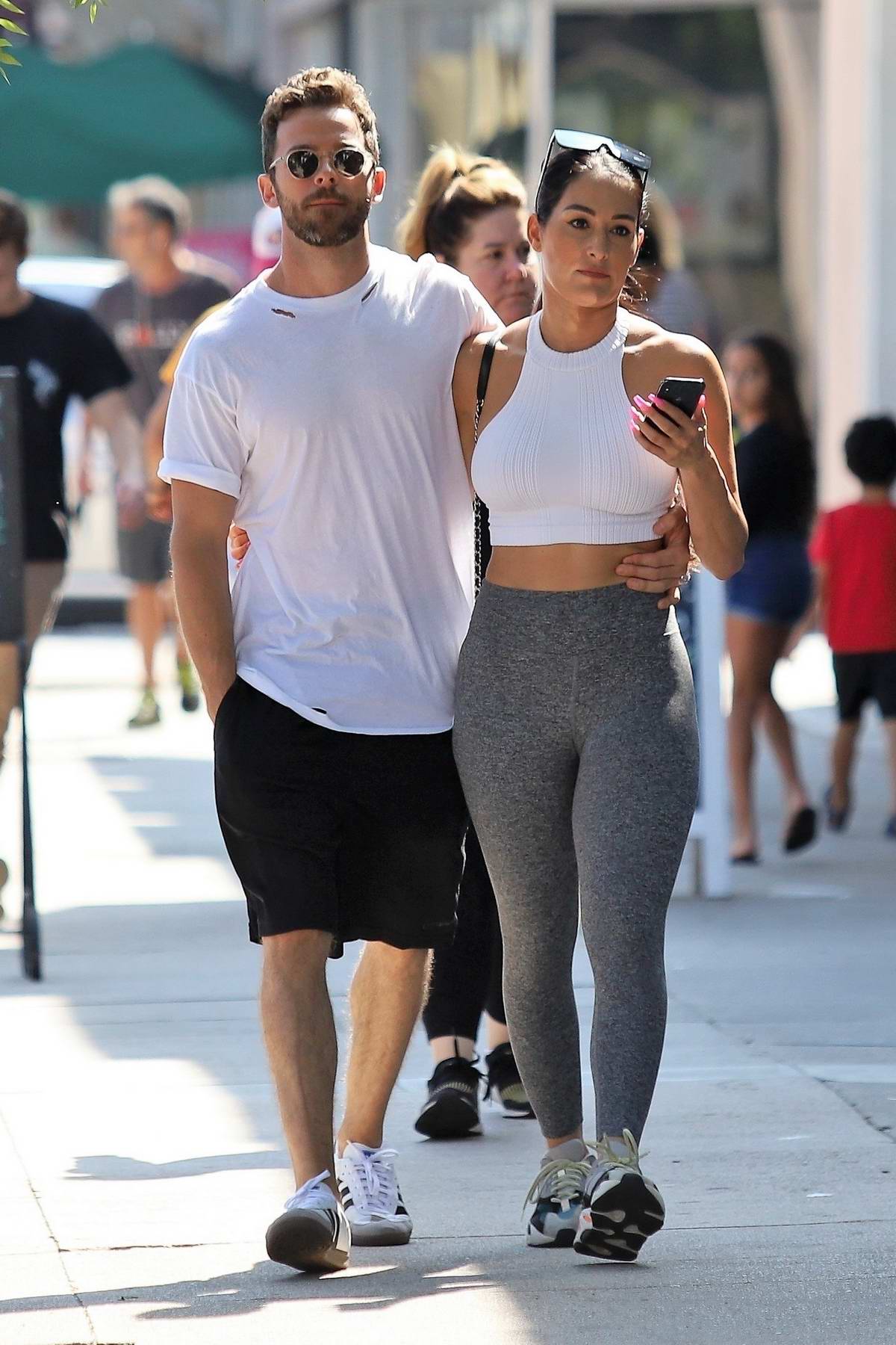 Nikki Bella wears a white crop top and grey leggings for a lunch