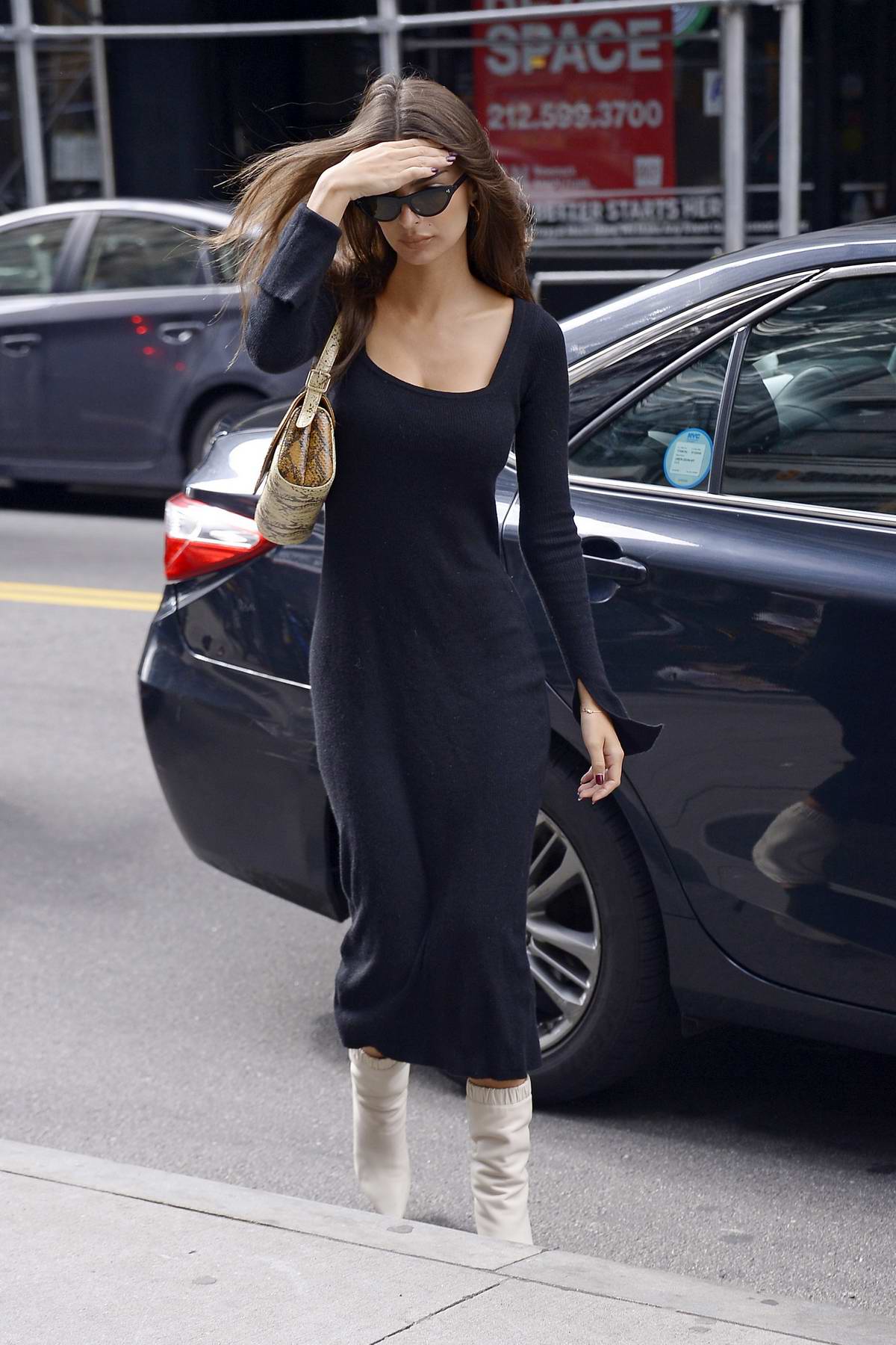 Emily Ratajkowski seen wearing a black long dress and white boots