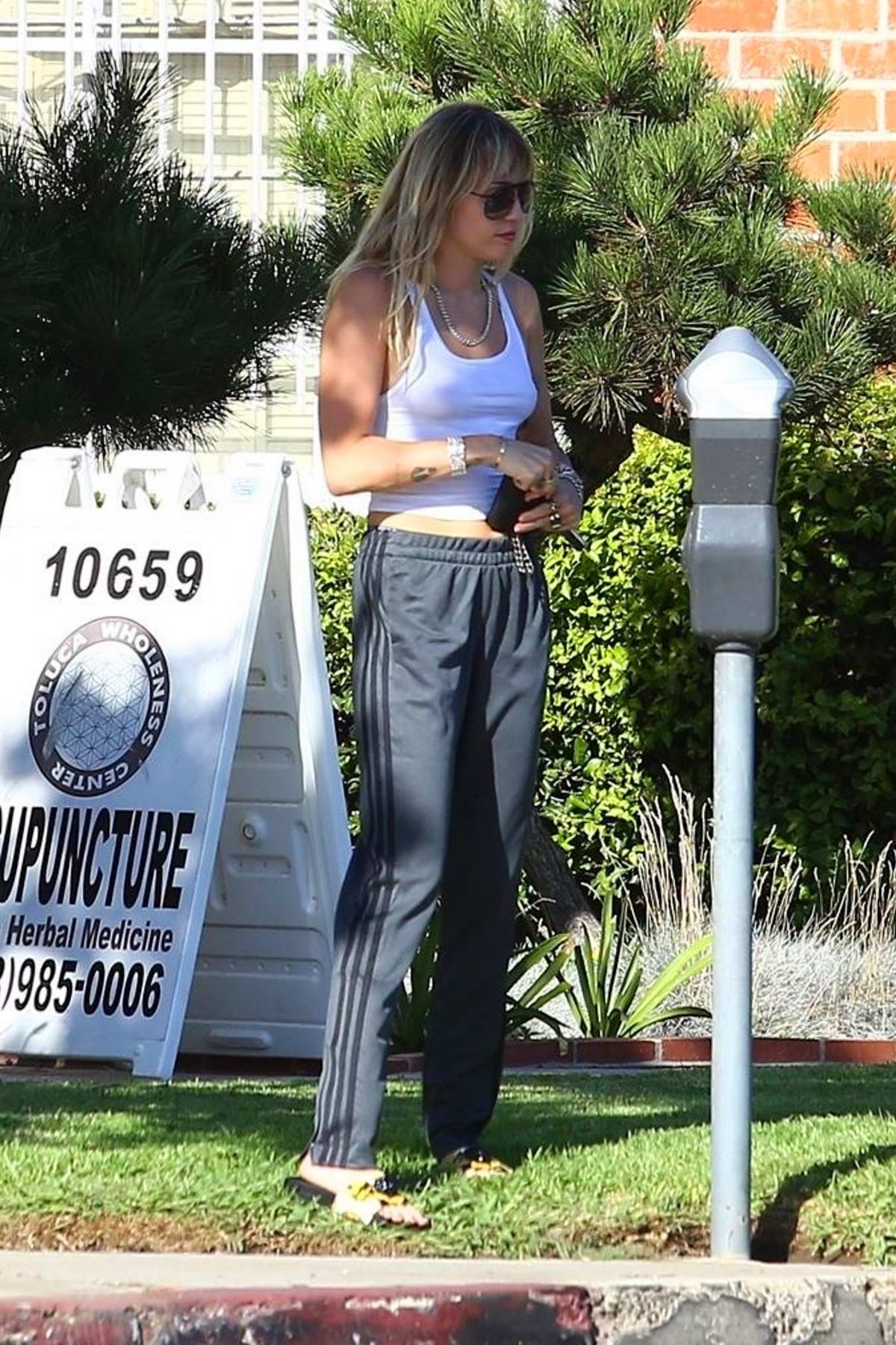 miley cyrus seen wearing a white tank top and adidas track pants as she  leaves after a yoga class in los angeles-060919_8