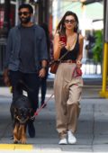 Emily Ratajkowski wears a black low cut tank top and brown trousers as she takes her pup Colombo to the park in New York City