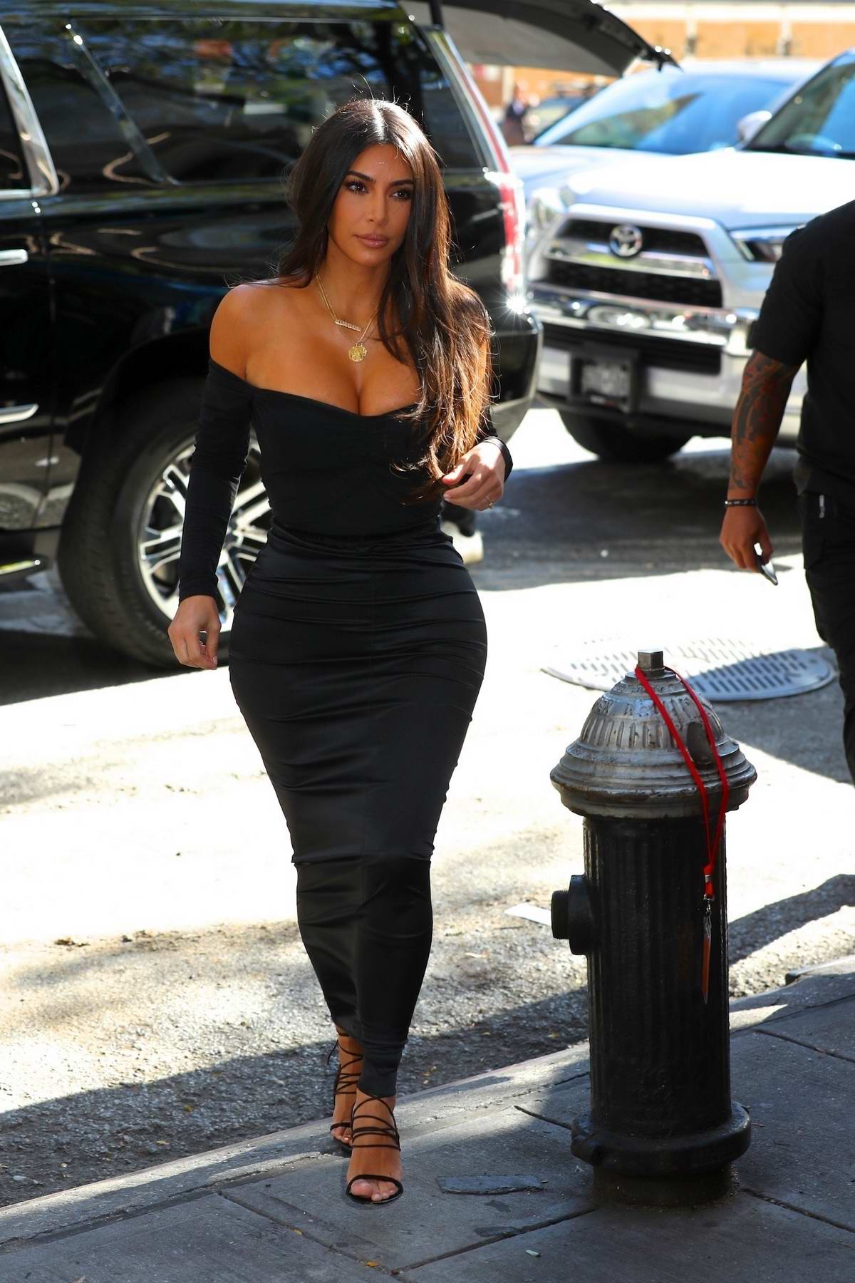 kim kardashian stuns in a form-fitting yellow dress as she arrives