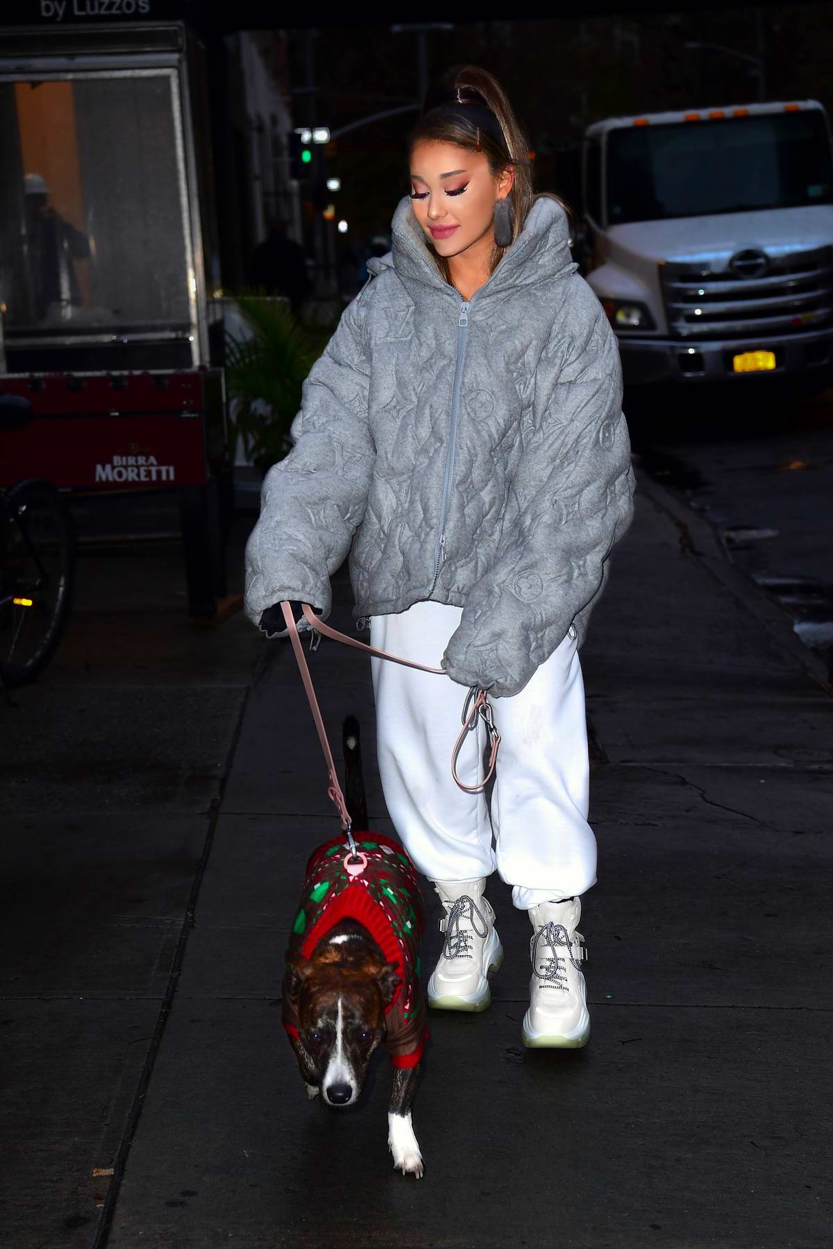 Ariana Grande in grey puffer jacket and cream high top sneakers in