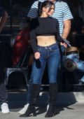 Ariel Winter bares her midriff in a black crop top and jeans during a ...