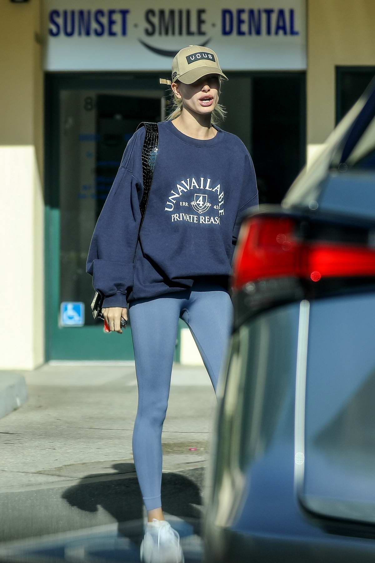 hailey bieber rocks a blue sweatshirt and grey leggings as she attends ...