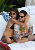 Kaia Gerber spotted in a black bikini as she packs on the PDA with Pete Davidson while relaxing by the pool in Miami, Florida